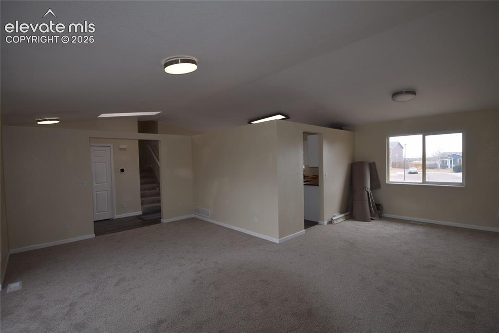 Image 34 of 45: Spacious room featuring neutral carpeting and light-colored walls