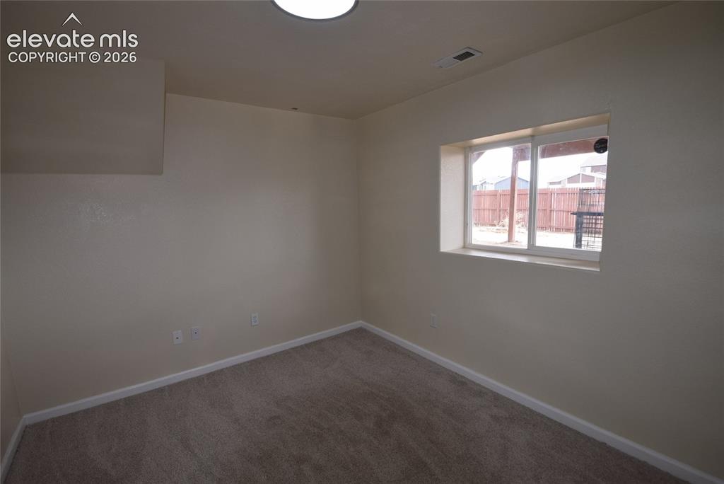 Image 37 of 45: Carpeted room featuring a window with a white frame and sill, neutral wall 