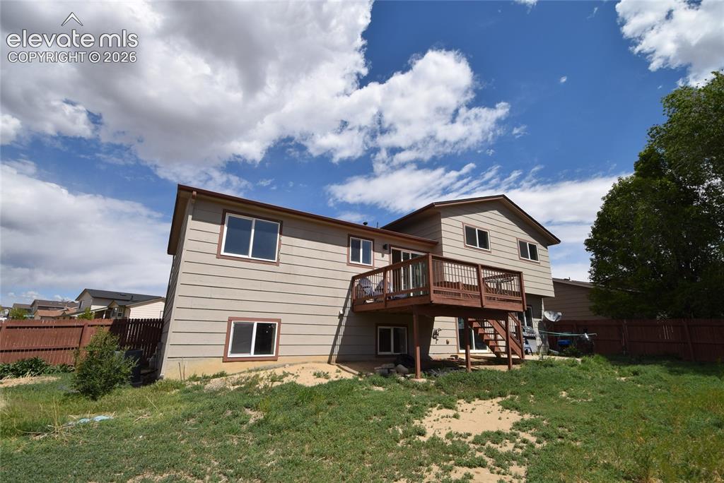 Image 4 of 45: Expansive exterior featuring a wood-finish multi-level deck, beige siding, 