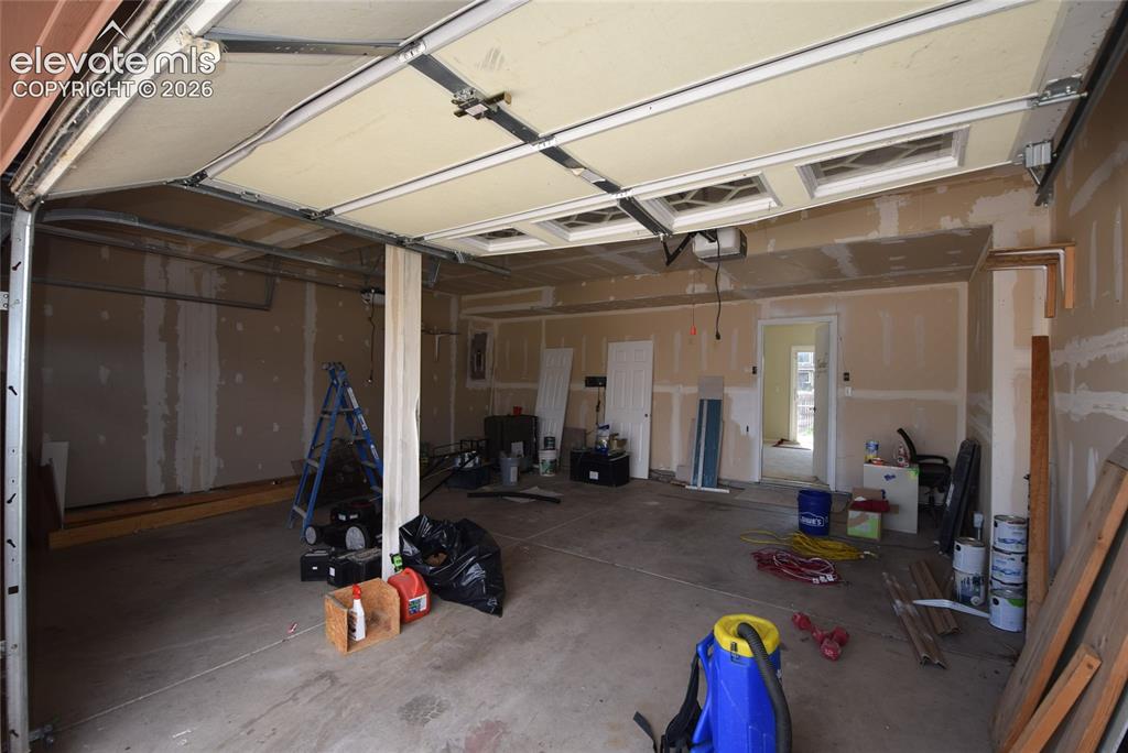 Image 45 of 45: Spacious garage interior featuring an overhead garage door with upper windo
