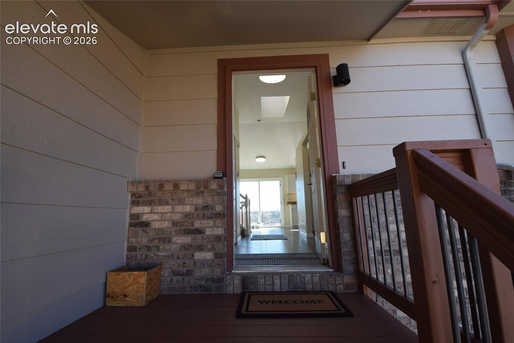 Image 5 of 45: Inviting entry porch featuring composite decking, brick facade accents, hor