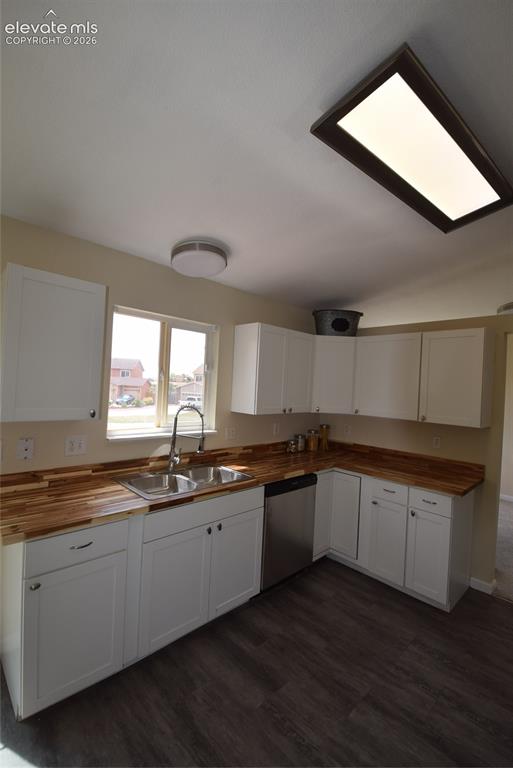 Image 9 of 45: Kitchen featuring white cabinetry, butcher block countertops, a stainless s