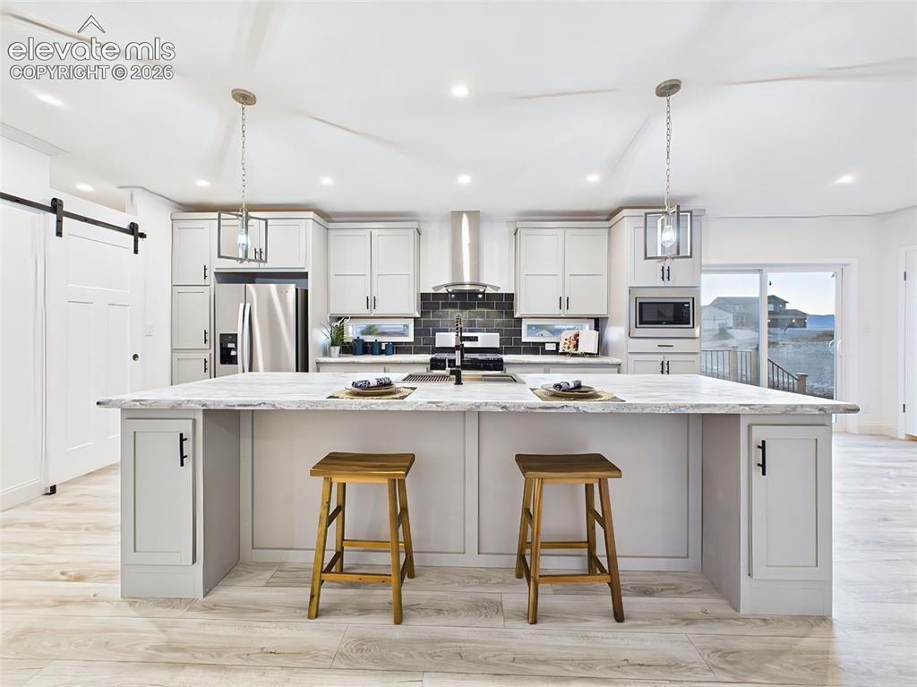 Image 11 of 50: Spacious gourmet kitchen featuring a large center island, stainless steel a