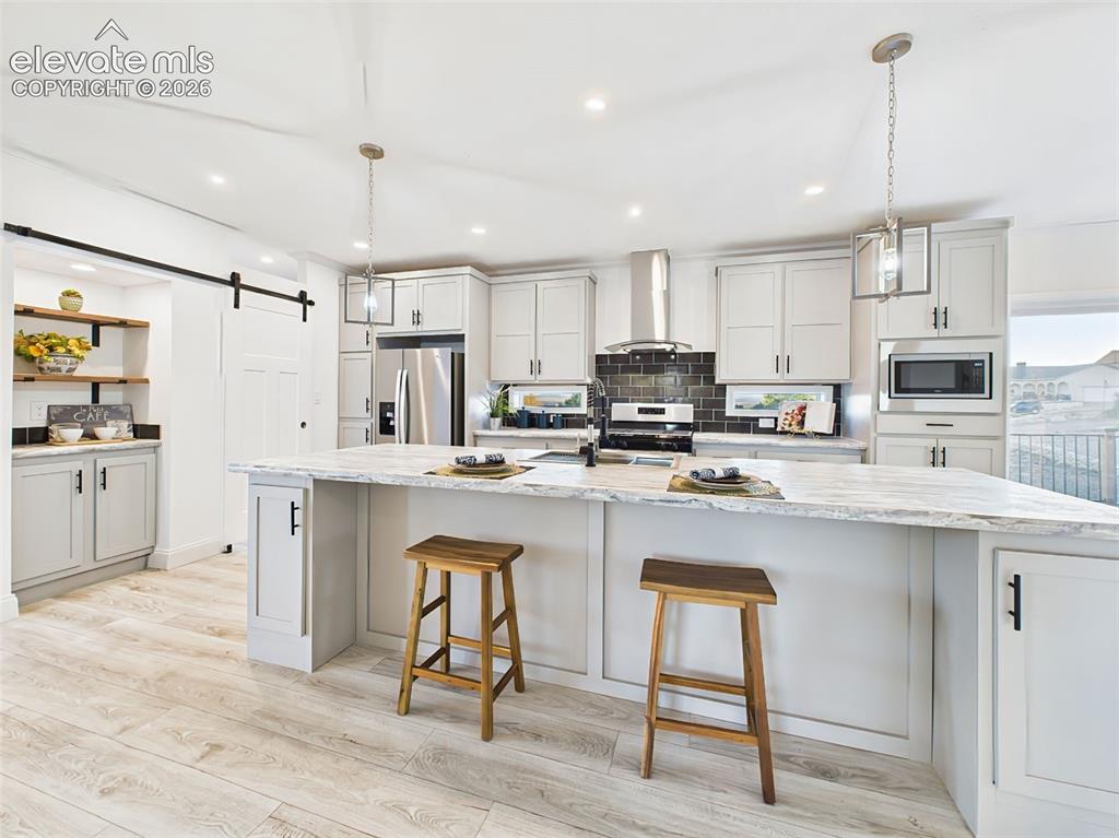 Image 12 of 50: Spacious kitchen with an oversized center island, abundant cabinetry, stain