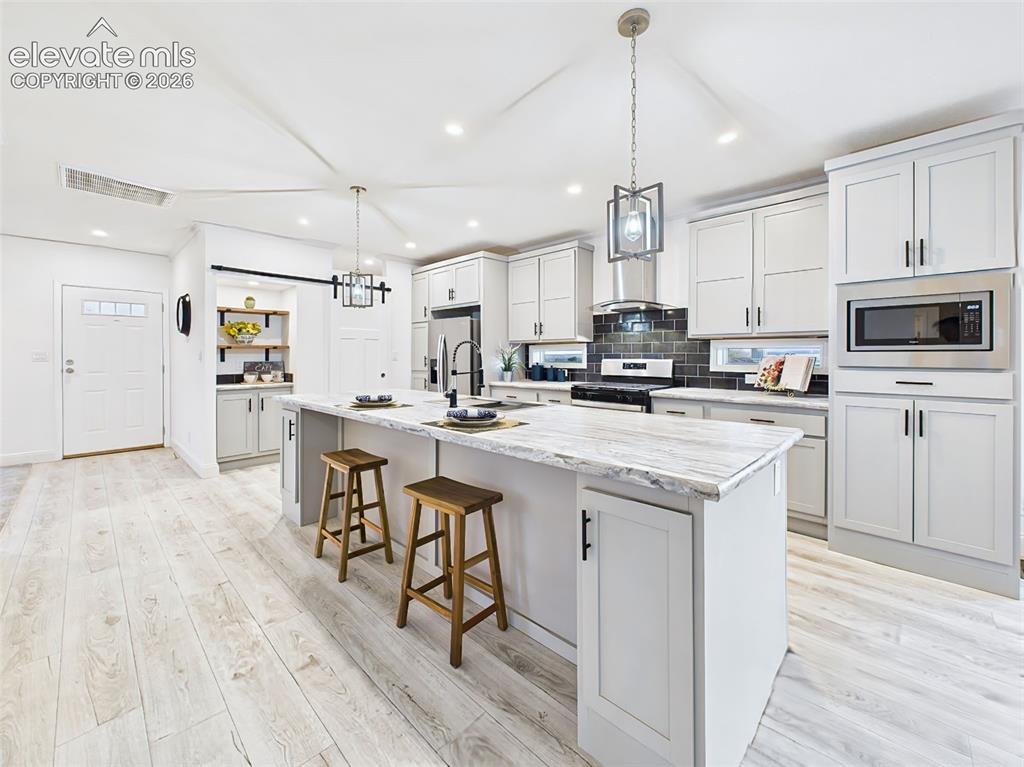 Image 13 of 50: Expansive countertops with room for seating and meal prep, highlighted by m