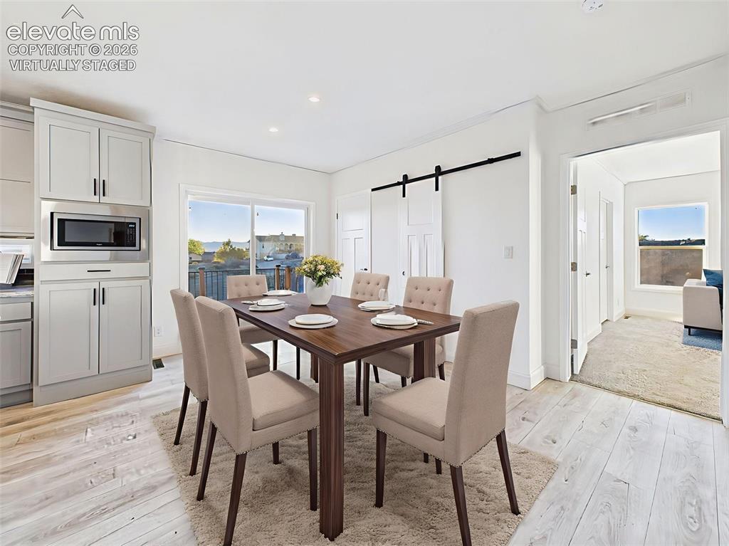 Image 20 of 50: Virtually Staged dining area showing seamless flow to the kitchen and deck 