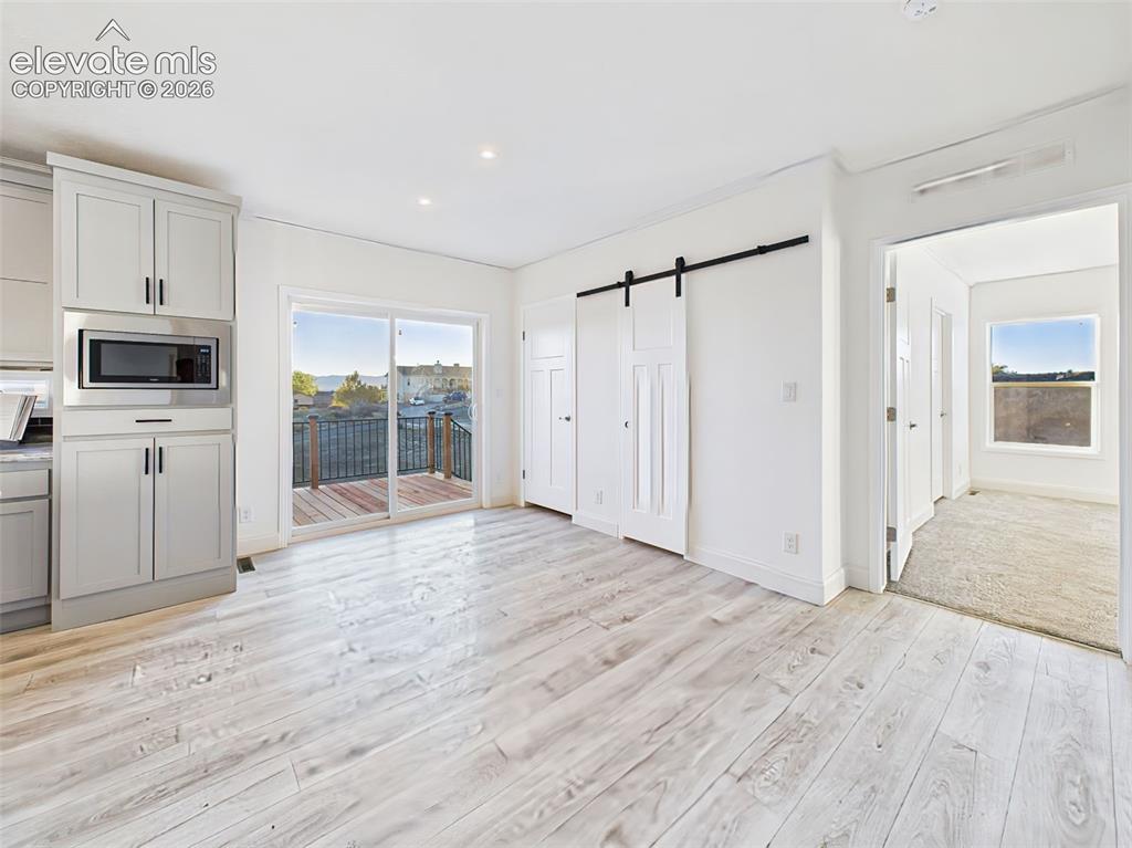 Image 21 of 50: Bright dining area with sliding glass doors leading to the side west facing
