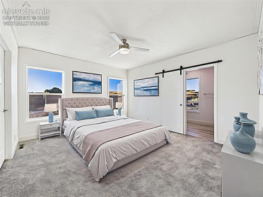 Image 26 of 50: Virtually Staged Spacious primary suite with bright natural light, plush ca