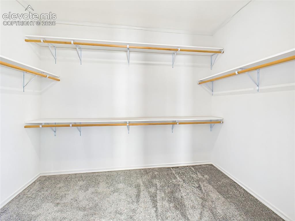 Image 30 of 50: Generous walk-in closet with custom shelving and abundant storage.
