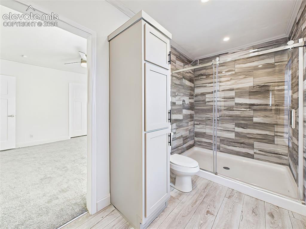 Image 32 of 50: Spacious walk-in shower with full tile surround and built-in linen cabinetr