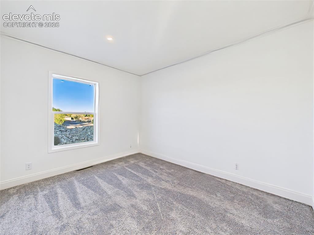 Image 37 of 50: Unstaged version bedroom 3 highlighting new carpet, recessed lighting, and