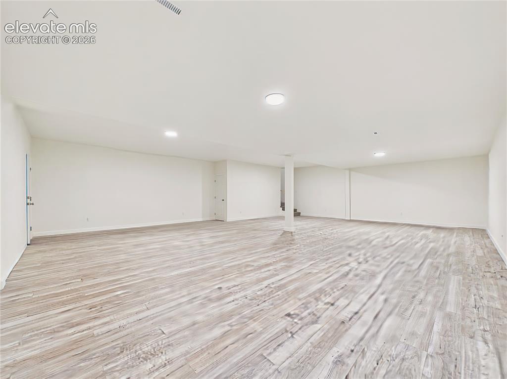 Image 44 of 50: Finished Basement – Another view highlights the basement’s wide-open layout
