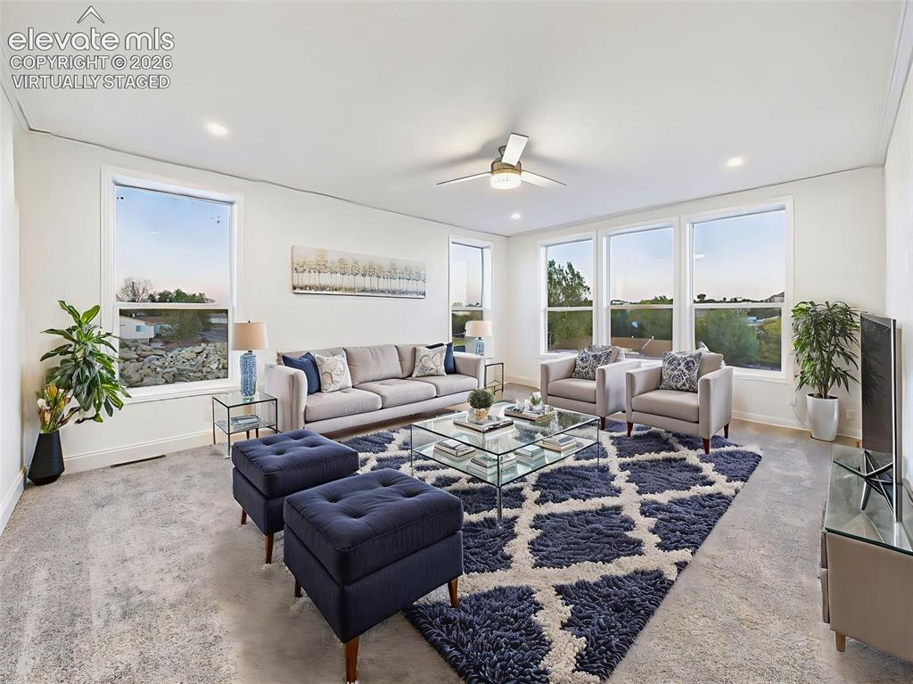 Image 6 of 50: Virtually Staged Living room with ceiling fan looking into kitchen