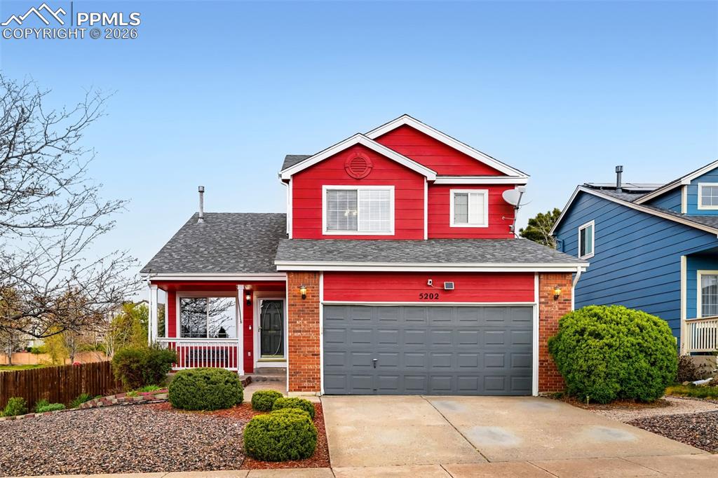 Caption: Two-story residence featuring a red siding exterior with brick accents