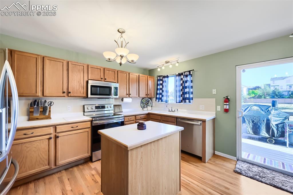 Image 10 of 32: Kitchen featuring wood-finish flooring, light wood cabinetry, white counter