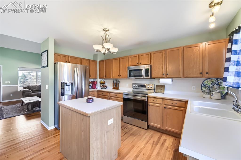 Image 11 of 32: Kitchen featuring wood-finish flooring, light wood cabinetry, stainless ste