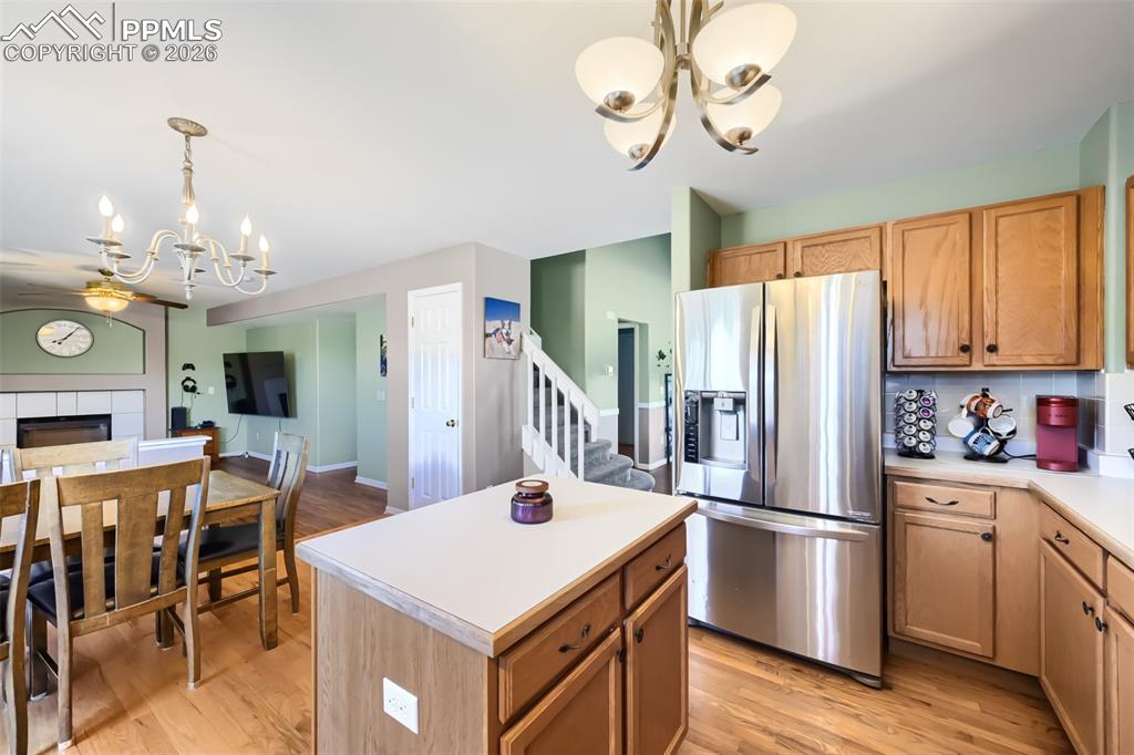 Image 12 of 32: Kitchen and dining area featuring wood-finish flooring, a central island wi