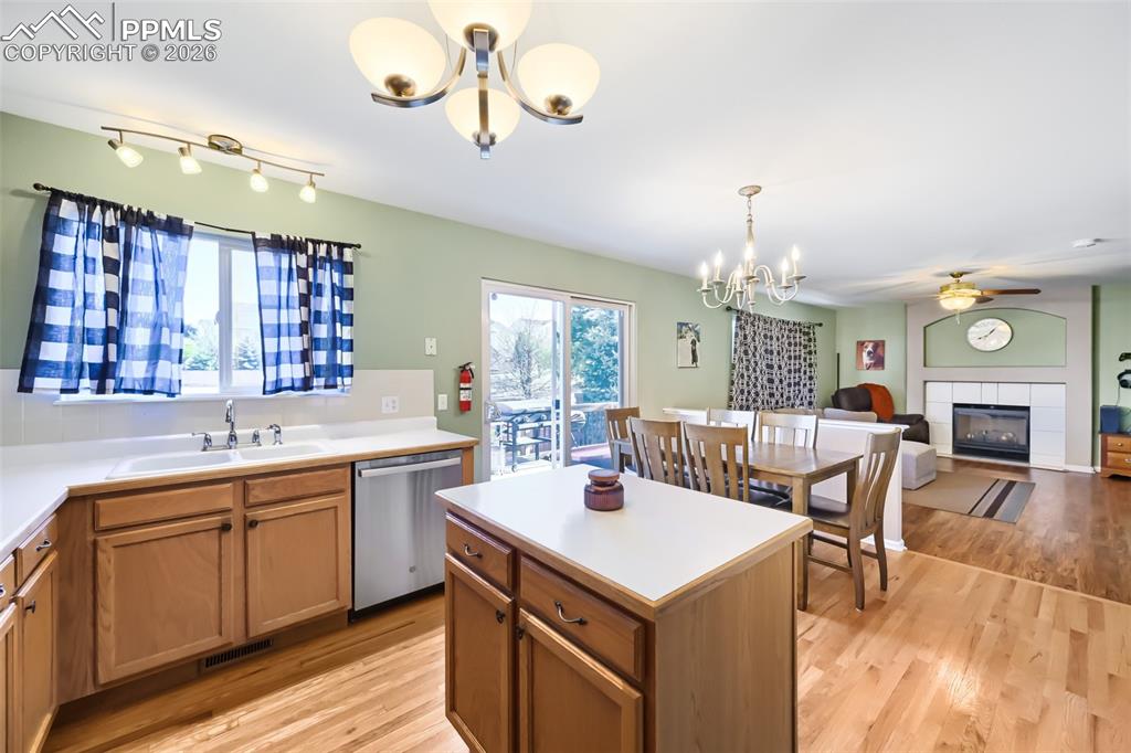 Image 13 of 32: Kitchen featuring wood-finish flooring, light wood cabinetry, a center isla