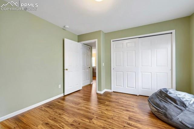 Image 15 of 32: Room with light green walls and wood-finish flooring