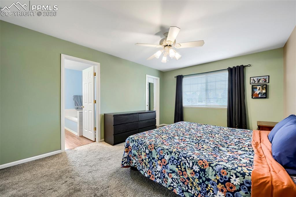 Image 18 of 32: Carpeted room with a ceiling fan light fixture and a window with blinds