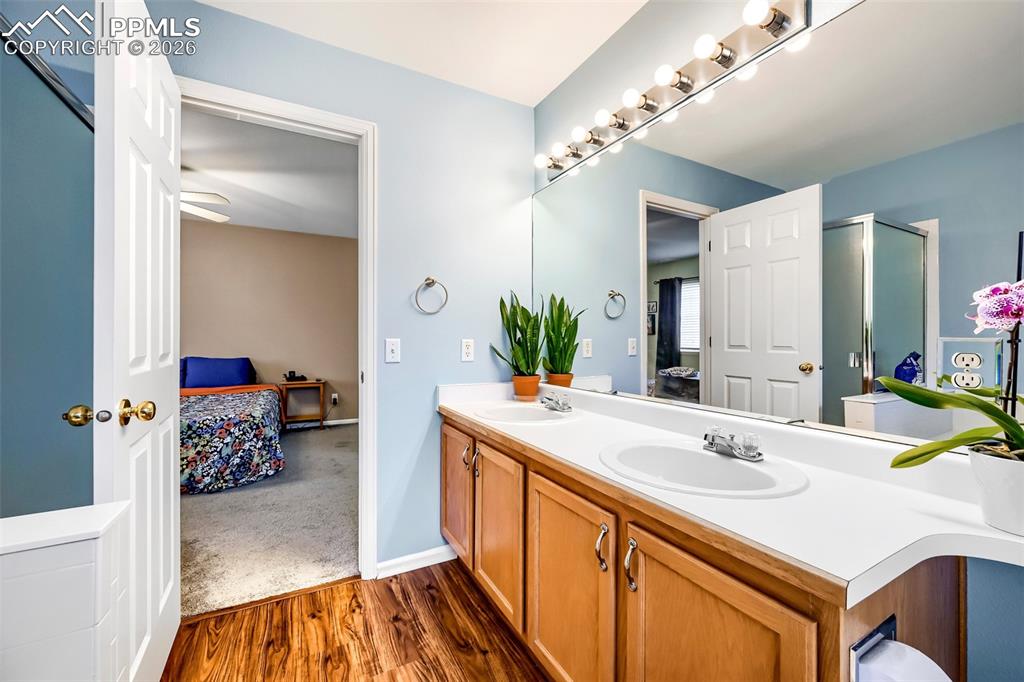 Image 22 of 32: Bathroom vanity featuring dual inset sinks, a white countertop, and light w