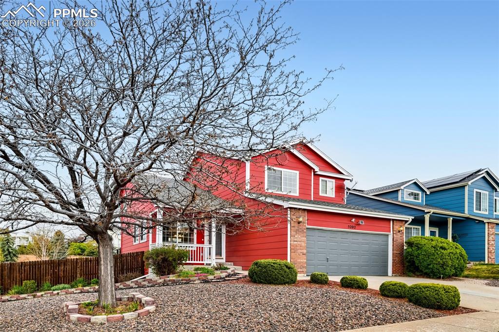 Image 3 of 32: Two-story residence featuring a red exterior with white trim