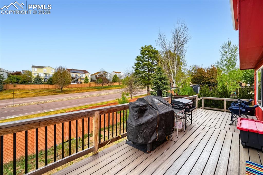 Image 30 of 32: Outdoor decking area featuring composite wood-finish boards, a wood railing