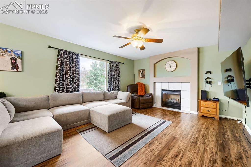 Image 8 of 32: Living area featuring wood-finish flooring, a ceiling fan with integrated l
