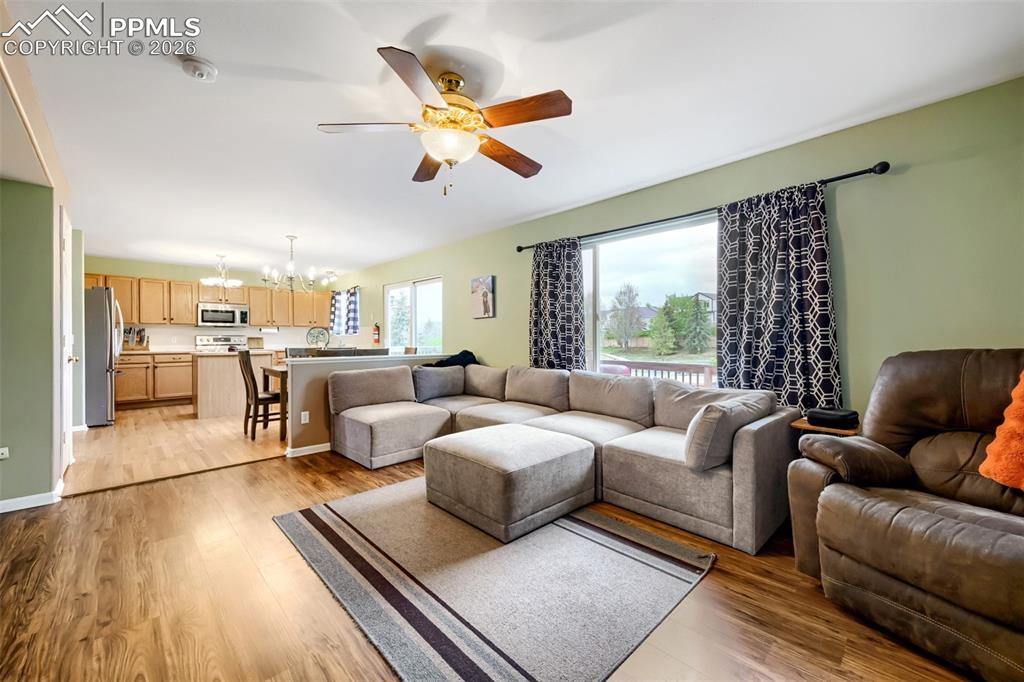 Image 9 of 32: Open-concept living space featuring wood-finish flooring and a ceiling fan 