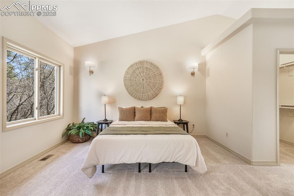 Image 12 of 50: Spacious living area featuring a floor-to-ceiling stacked stone fireplace w