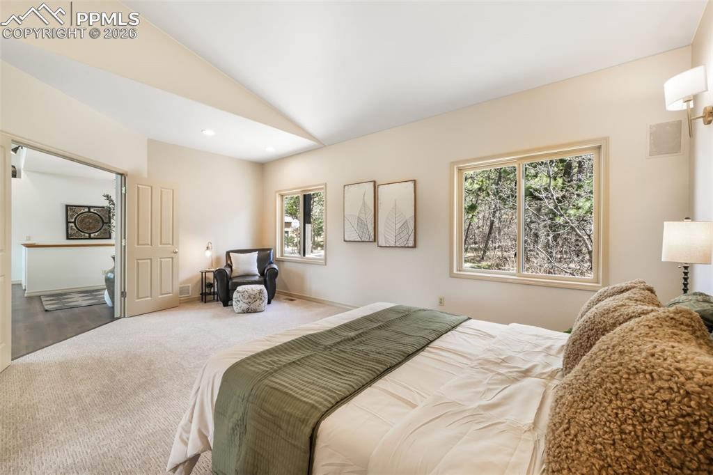 Image 13 of 50: Vaulted ceilings with track lighting accent a living area featuring dark wo