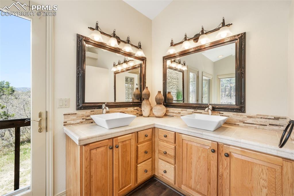 Image 16 of 50: Spacious room featuring vaulted ceilings, a large window, wall-mounted scon