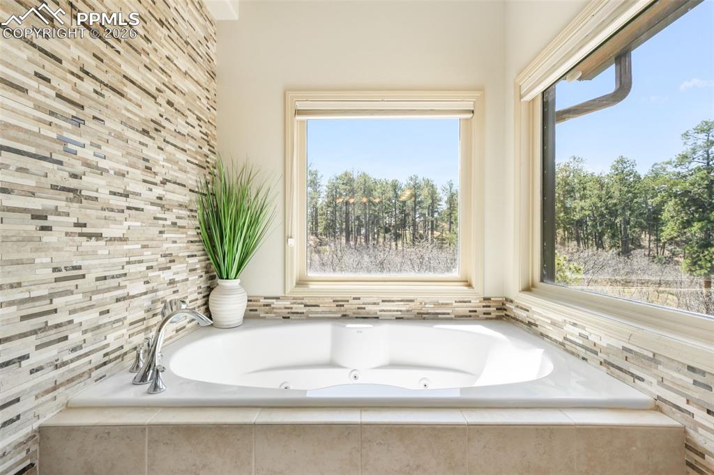 Image 18 of 50: Walk-through hallway featuring two open closets with shelving and hanging r