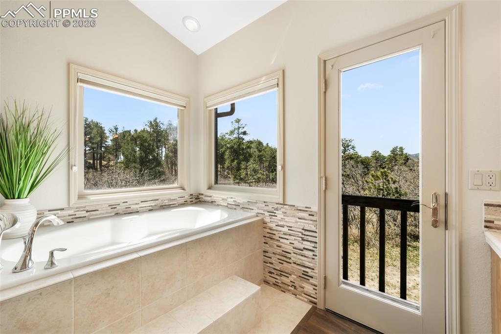 Image 19 of 50: Glass-enclosed shower with tile surround and glass block window