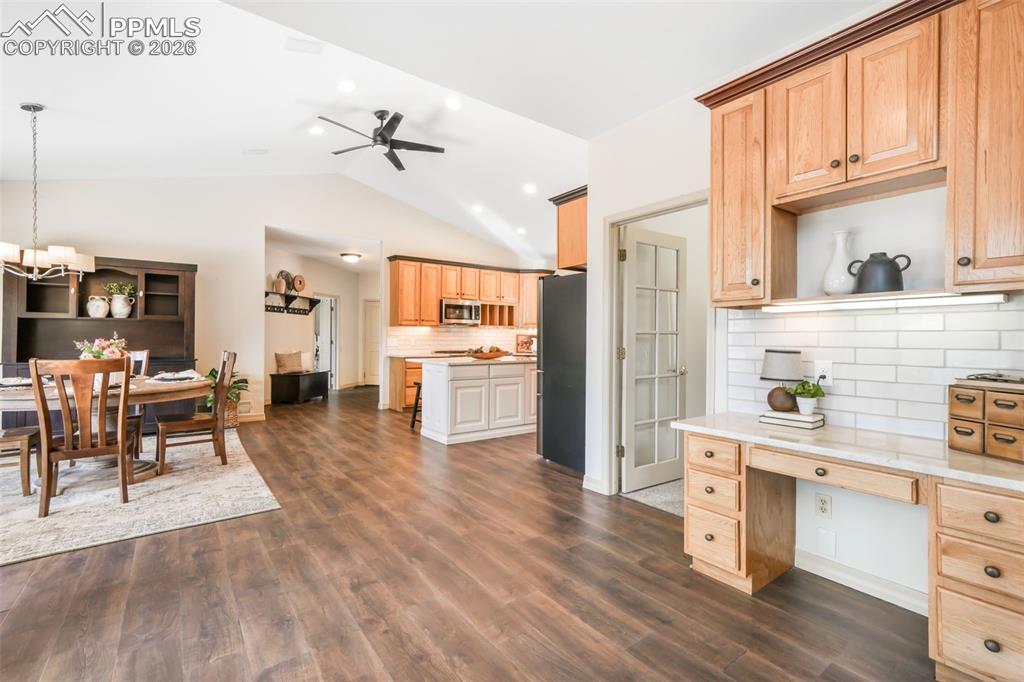 Image 21 of 50: Vanity with dual vessel sinks, wood cabinetry, and a mosaic tile backsplash
