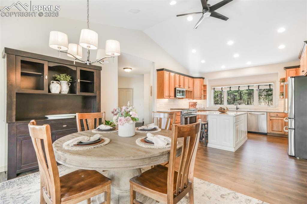 Image 24 of 50: Spacious living room featuring a vaulted ceiling with exposed wood beams, e