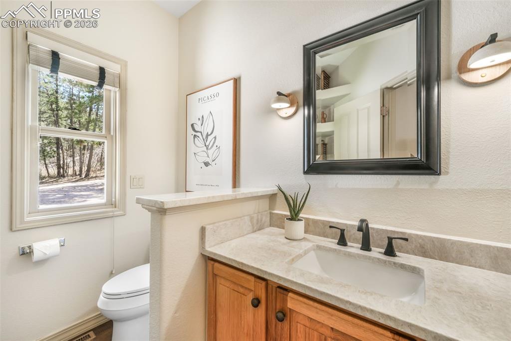 Image 30 of 50: Open-concept kitchen featuring an expansive central island with a light-ton