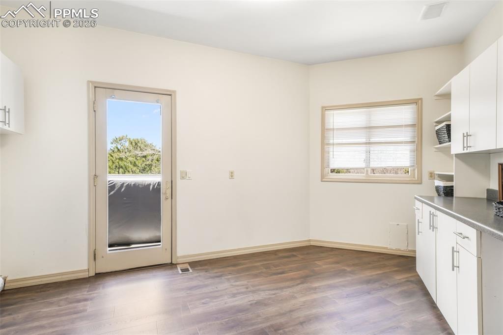 Image 31 of 50: Kitchen with natural wood cabinetry, light-toned countertops, and a subway 