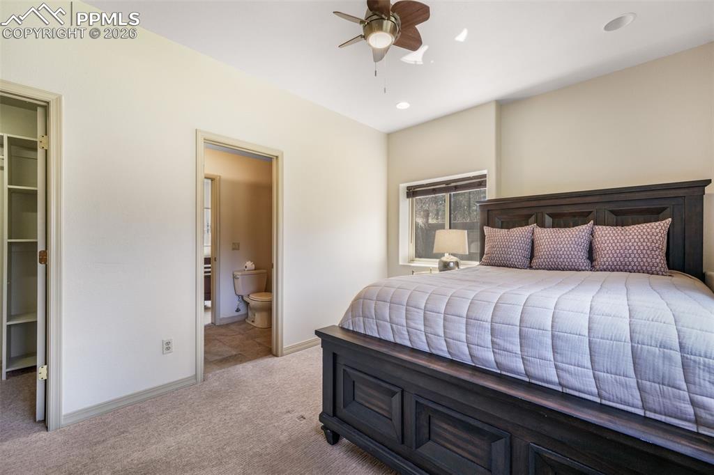 Image 38 of 50: Carpeted lounge area featuring a stone accent wall, recessed lighting, and 