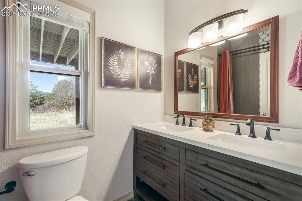 Image 41 of 50: Double vanity featuring oak-finish cabinetry, integrated sinks, and a lamin