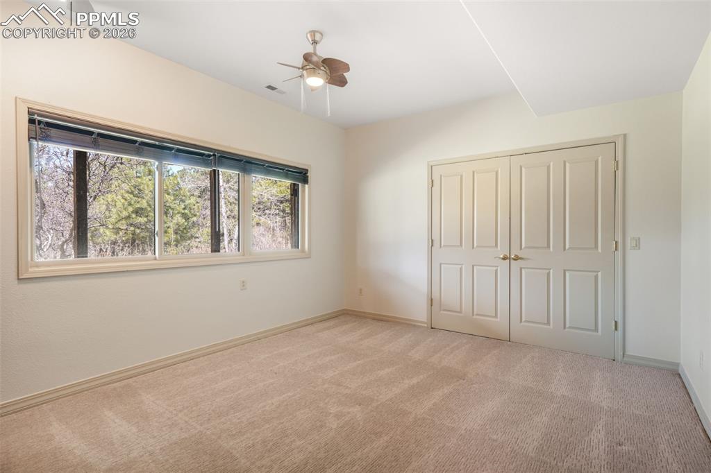 Image 42 of 50: Carpeted room with a ceiling fan, recessed lighting, and a window with a va