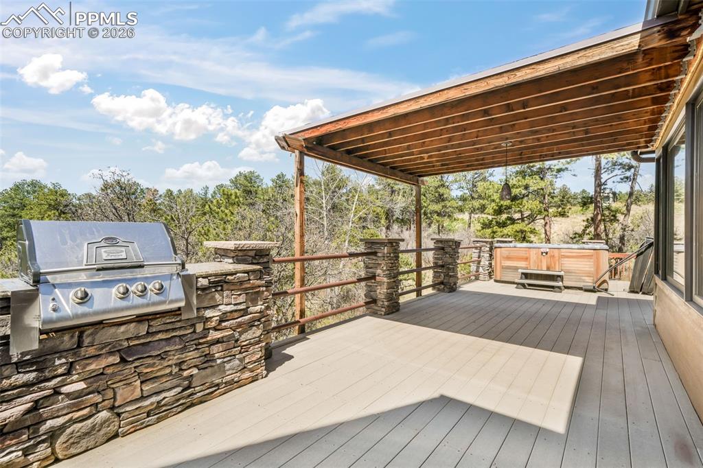 Image 46 of 50: Light-filled room featuring a broad window with forested scenery, a texture