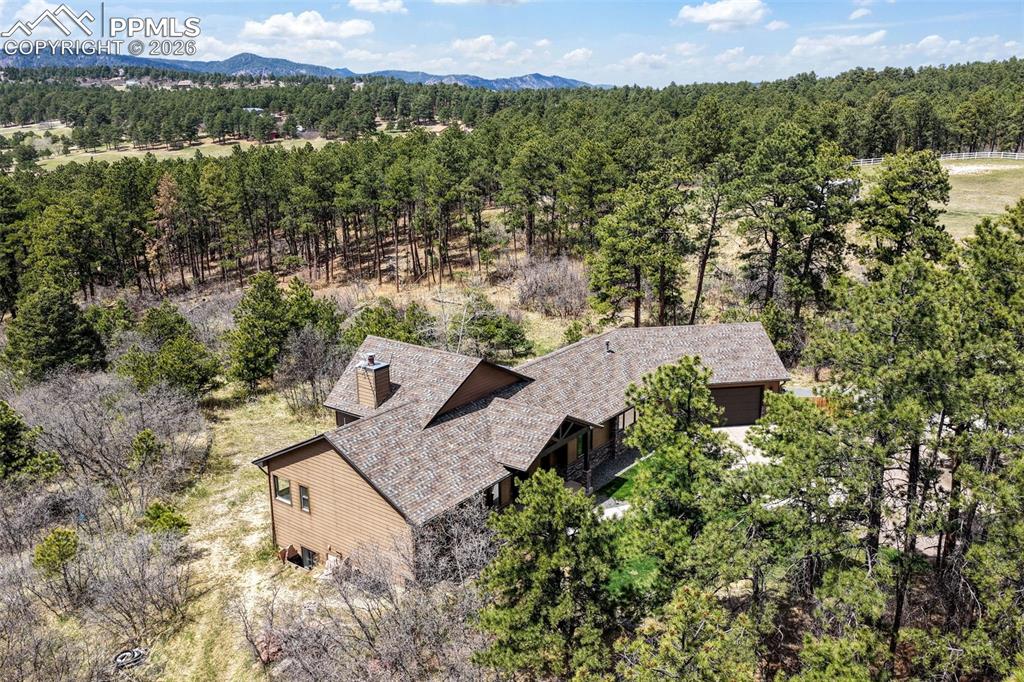 Image 50 of 50: Expansive outdoor deck featuring a built-in stone grill, a wood-sided spa, 