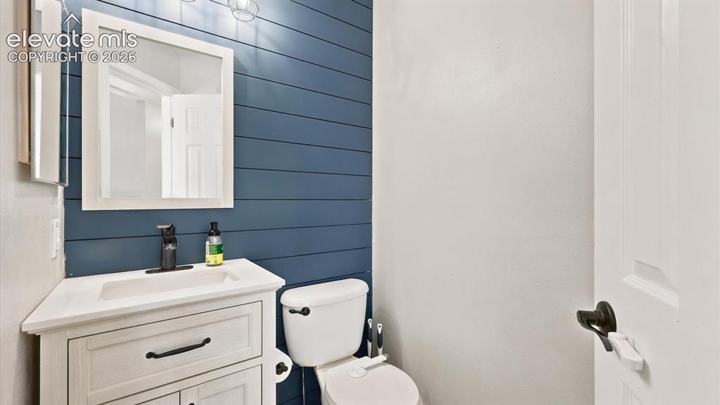 Image 11 of 50: Convenient main level Powder Bathroom with vanity, framed mirror, and attr