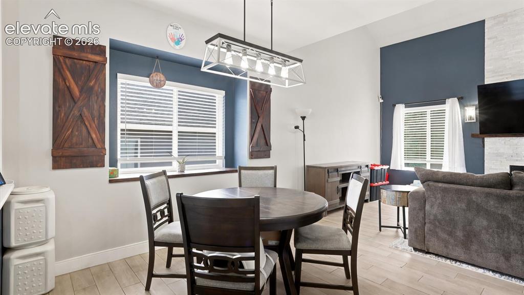 Image 13 of 50: The Dining Area has a modern light fixture and inset window with attractive