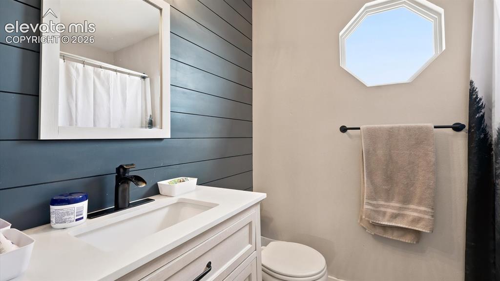 Image 20 of 50: Upper Level renovated Bathroom with vanity, framed mirror, accent wall, and
