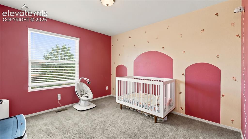 Image 25 of 50: Upper Level Bedroom #3 features neutral carpet and designer paint tones.