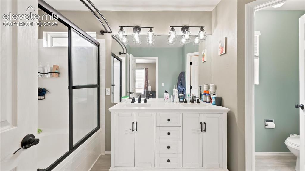 Image 30 of 50: The Primary Bathroom features a dual sink vanity, mirror, and enclosed tile