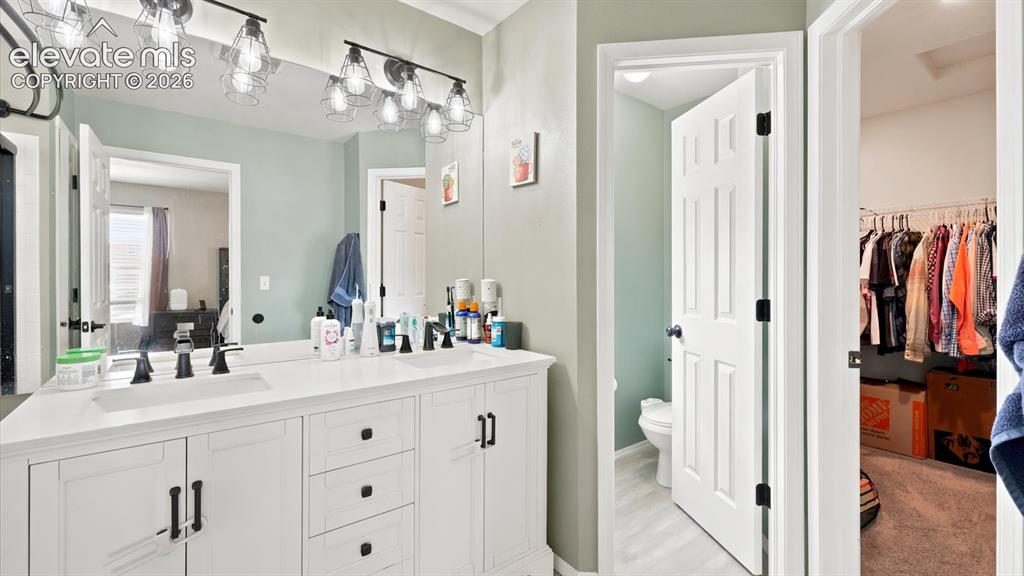 Image 31 of 50: Upper Level Primary Bathroom with view into the walk in closet.