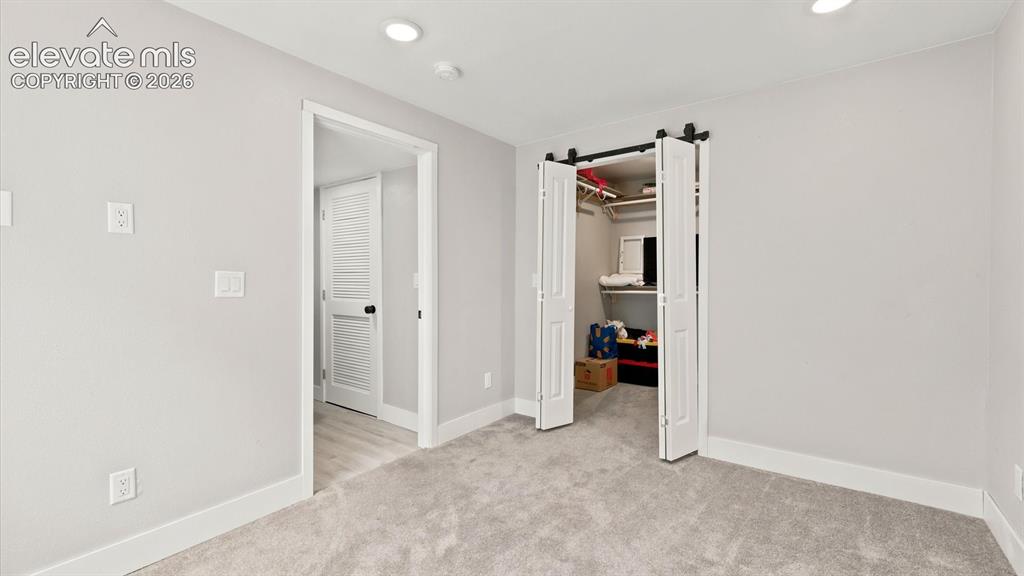 Image 39 of 50: Basement Bedroom #4 with neutral carpet.
